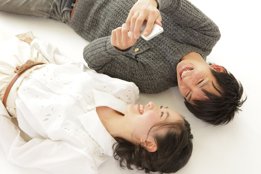 笑顔で寝そべるカップル